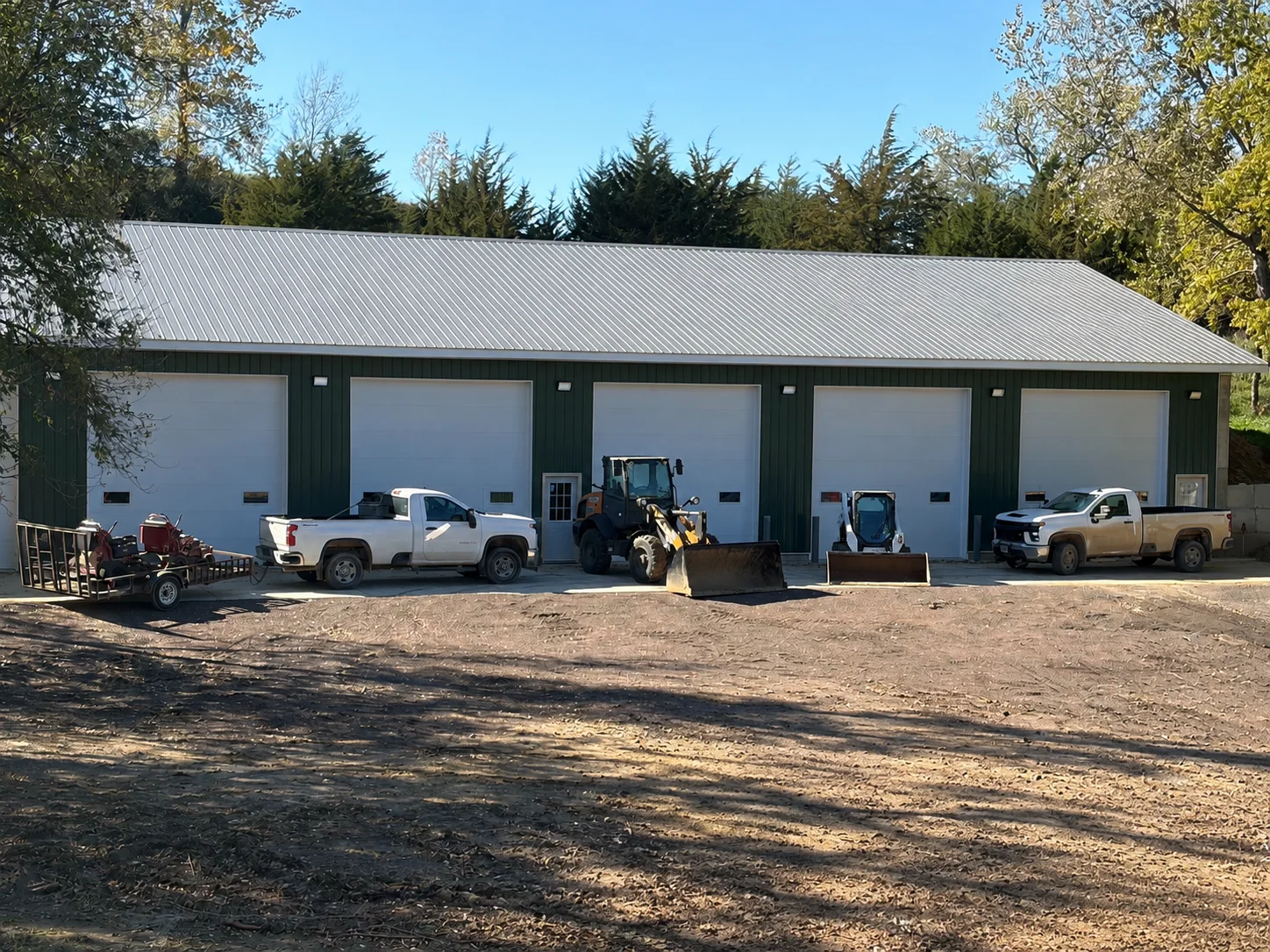 GreenSpace equipment and work trucks parked outside a shop